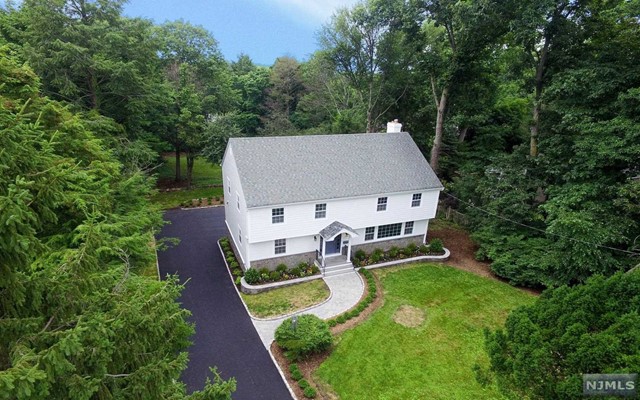Sited On Tenafly's East Hill on a 30492 sq. ft. property. Totaly redone in 2016 Featuring 4 huge  bedrooms on the second floor with 3 full bathrooms. Large open space living room, dining room and, a family room that has slider that open to a huge new deck ovelooking the estate like property. The White kitchen features all new appliances ( Bosch, JenAir, Sharp, Kenmore ), new cabinetry and an island, has sliders to the large deck as well.  The family room features a wood burning fire place. A full refinished basement & is a walk out to the rear and opens to the two car garage. Other improvements include; new Hardie Plank siding , new driveway, new landscaping, new electric box including new electric from the street to the box, new Samsung washer/dryer, new central air handler and condenser....minutes to Maugham elementary ....