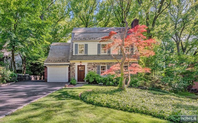 Expanded and updated colonial    on the east hill of Tenafly nestled on 1/3 acre deep property with an absolutely phenomenal backyard. Upgraded kitchen and family room open to the stone deck with fire pit and whirlpool in total privacy. First floor offers large living room with fireplace open floor kitchen with large breakfast area, formal dining room & powder room and a mud room from the attached garage. The second floor offers master bedroom w/ newer full bath, 2 large bedrooms and an updated full bath. The walk up attic is fully finished air-conditioned and heated. The full finished basement has higher ceilings and a beautiful recreation room with a f/pl, laundry area and large storage room.. Beautiful hardwood floors 1st & 2nd floor newer multi zone central air & heating, .Walking distance to NYC Bus, houses of Worship and the Excellent Tenafly Schools